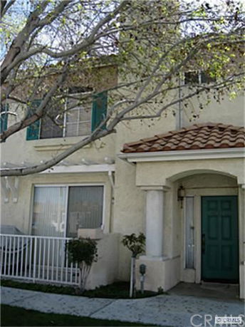 Front view of a two-story house with a green door and tiled roof.