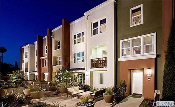 Front view of a modern multi-story apartment building at night.