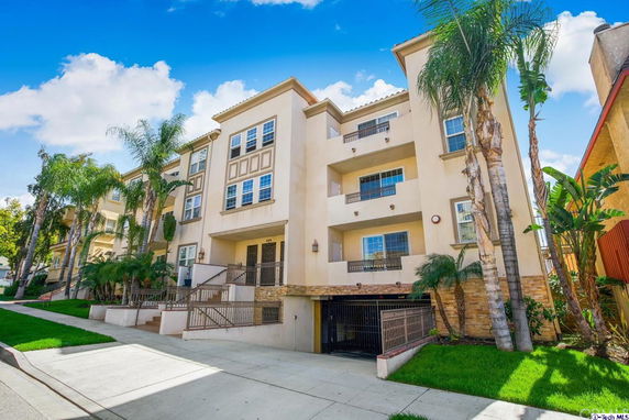 Front view of a multi-story residential building with balconies and garage.