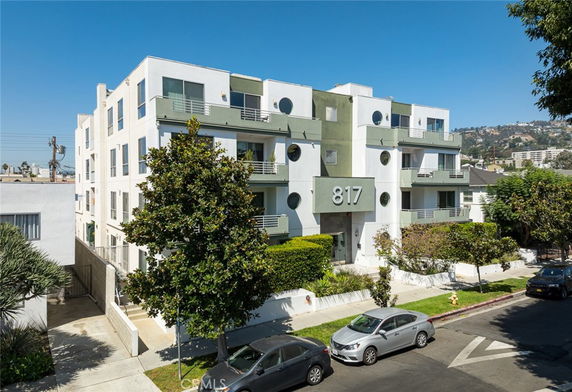 Front view of a multi-story residential building with distinctive circular windows and balconies.