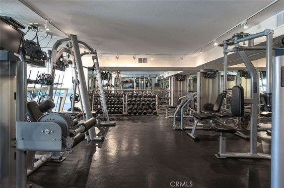 Indoor gym area with various fitness equipment and free weights.
