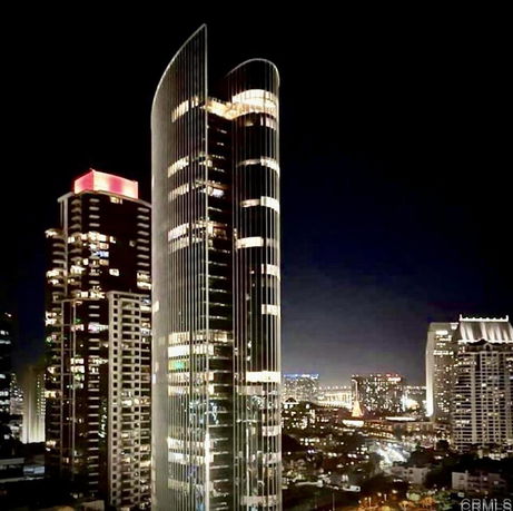 Front view of a modern, illuminated skyscraper at night.