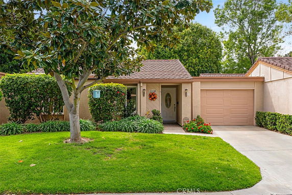 Front view of a single-story house with a garage and a small front yard.
