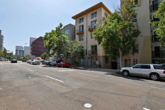 Street view with multi-story buildings on either side.