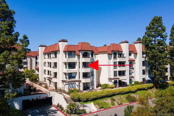 Front view of a multi-story apartment building with red tile roofing.