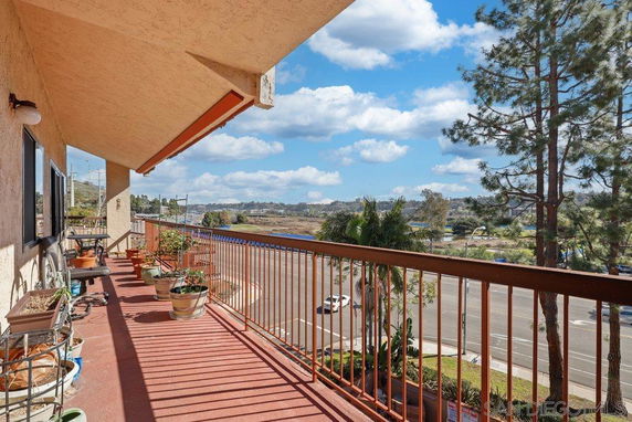Balcony view overlooking a road with trees and distant landscape.