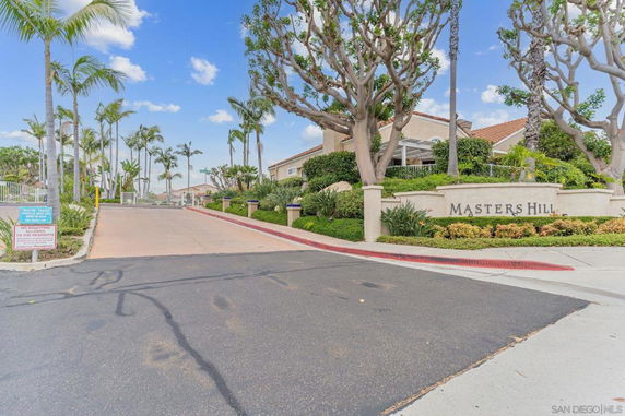 Front view of a residential area entrance with gated access and landscaped surroundings.