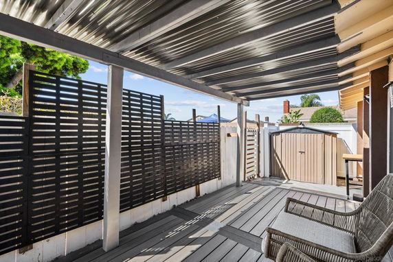 Covered rooftop area with lattice fencing and wicker furniture.