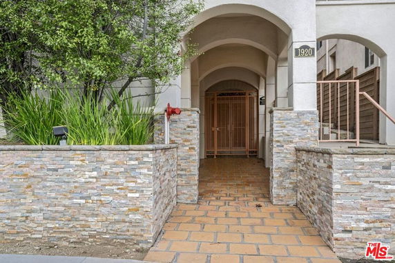 Entrance of a building with stone tiled walls and arched doorway.