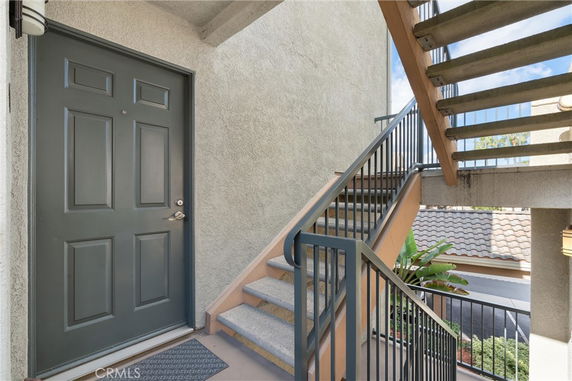 Exterior stairwell and entrance to a building with a visible green door.