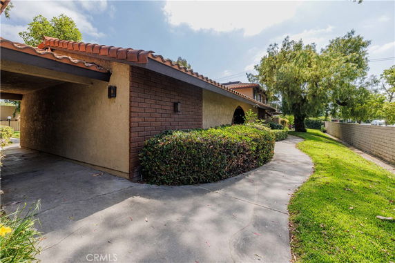 Front view of a single-story house with brick and stucco exterior and a covered walkway.