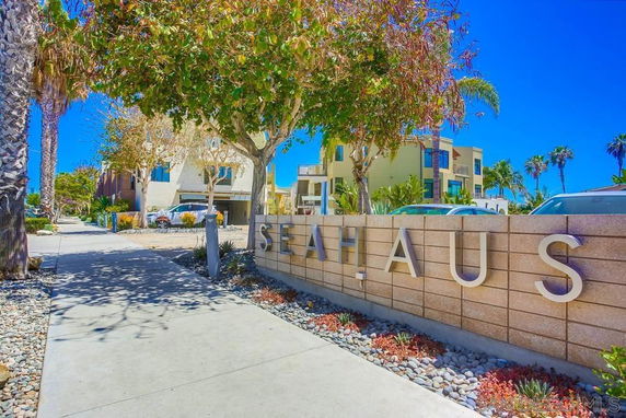 Front view of a modern multi-story building with a large stone sign.