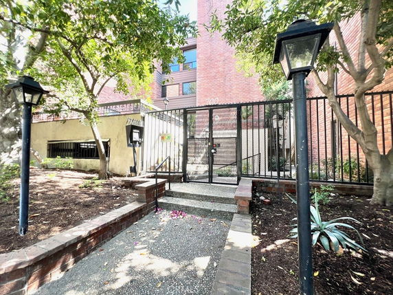 Front view of a brick exterior apartment building with a gated entrance.