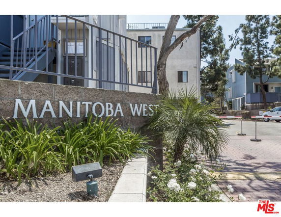 Front view of an apartment complex entrance with 'Manitoba West' sign.