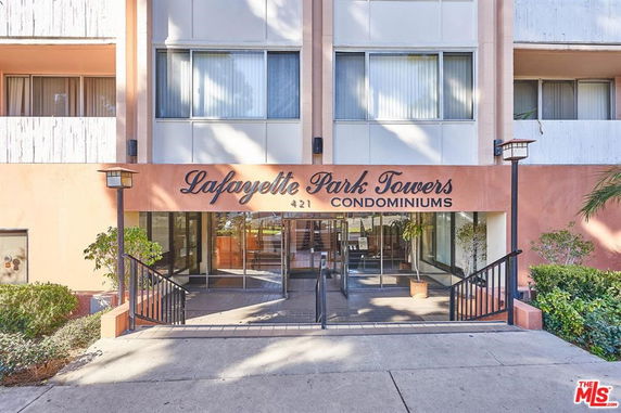 Front view of a multi-story condominium building entrance.