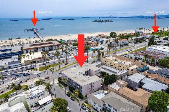 View showing multiple buildings near the beach with ocean and pier in the background.