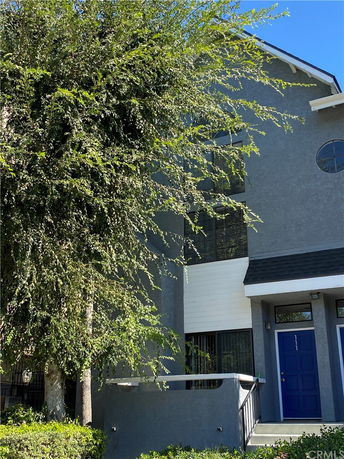 Front view of a multi-story building with a blue door and tall windows.