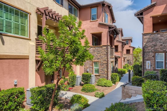 Front view of multi-story residential buildings with stone and stucco exteriors.