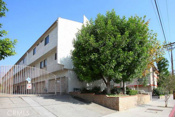 Front view of a multi-story building with a gated entrance.