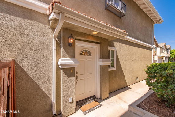 Front view of a house entrance with a white door and a small porch.