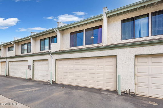 Front view of a row of townhouses with garages.