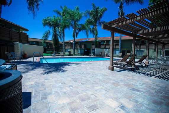 Outdoor swimming pool area with surrounding patio and lounge chairs.