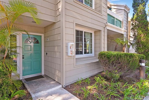 Front view of a two-story house with a green door and beige siding.