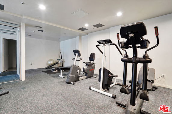 Indoor gym area with exercise equipment, including stationary bikes and an elliptical machine.