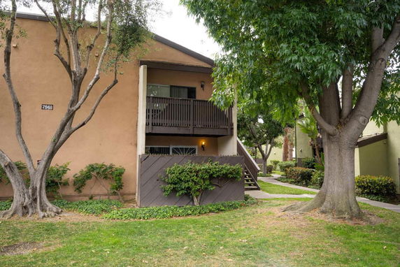 Front view of a two-story building with a balcony and staircase.