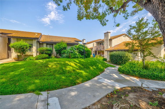 Front view of a multi-unit residential building with tiled roof and green landscaping.