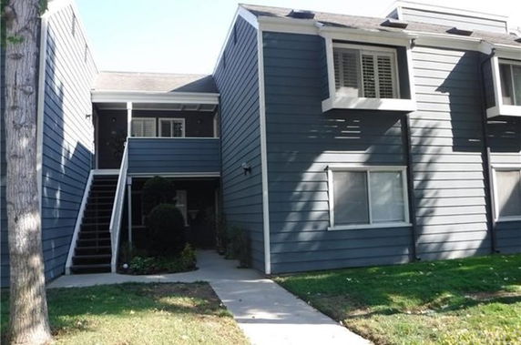 Front view of a two-story residential building with stairs leading to the upper level.