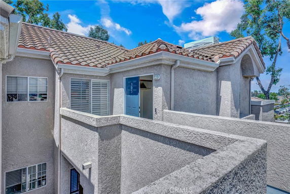 Front view of a residential building with a tiled roof and external staircase.