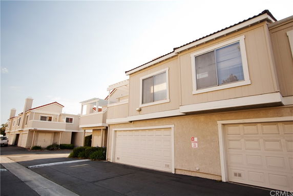 Front view of connected multi-story townhouses with garages.