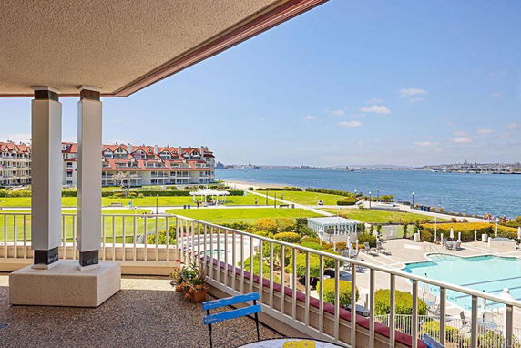 Panoramic view of waterfront area with residential buildings and pool.