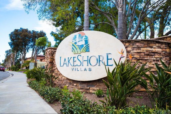Entrance sign of Lakeshore Villas with stone wall and landscaping.