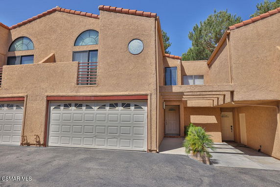 Front view of a multi-story building with double garage doors and arched windows.