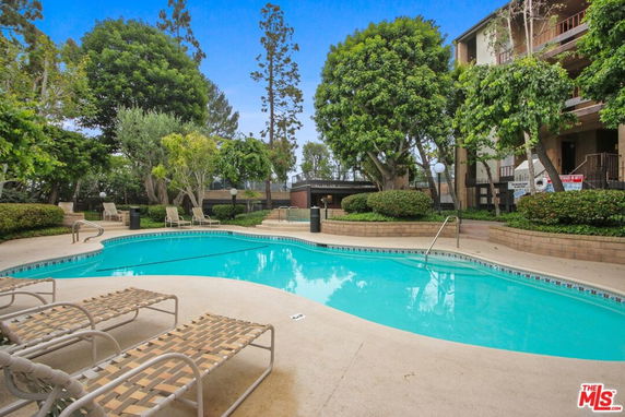 Outdoor swimming pool area with surrounding greenery.
