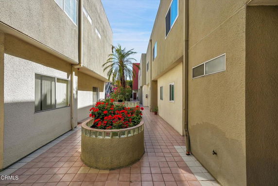 View of two-story residential building with exterior walkway.
