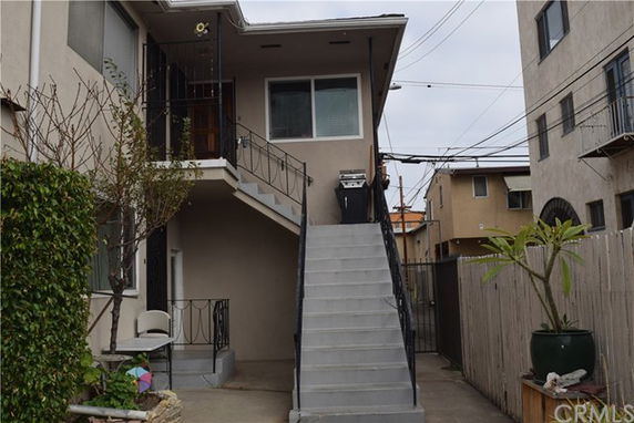 Front view of a two-story building with an outdoor staircase.