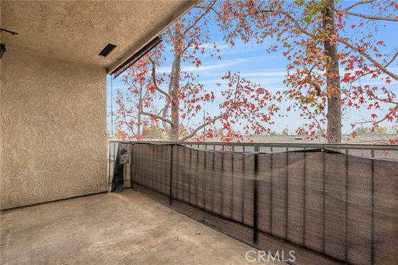 Outdoor area with protective railing, overlooking trees with autumn leaves.