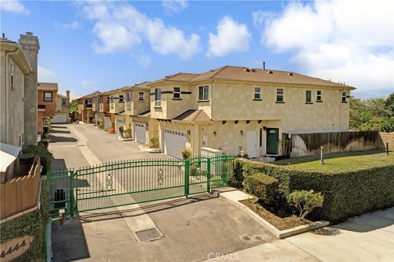 Front view of a gated community with multiple two-story houses.