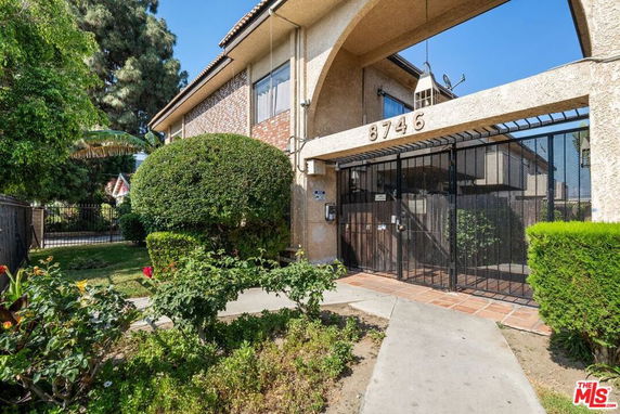 Front view of a building with an archway entrance and gated access.