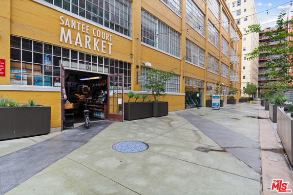 Front view of a building housing the Santee Court Market with large windows and an open entrance.