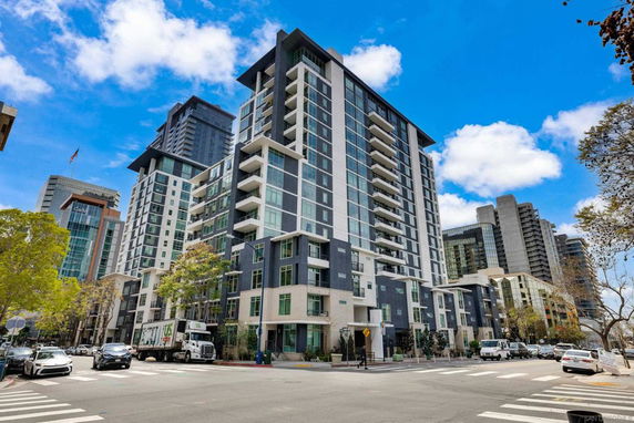 Front view of a multi-story residential building on a city street corner.