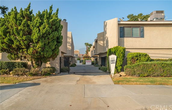 Front view of a multi-story building with a gated entrance.