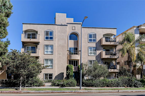 Front view of a four-story apartment building with balconies.