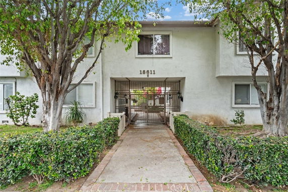 Front view of a two-story apartment building with a gated entrance.