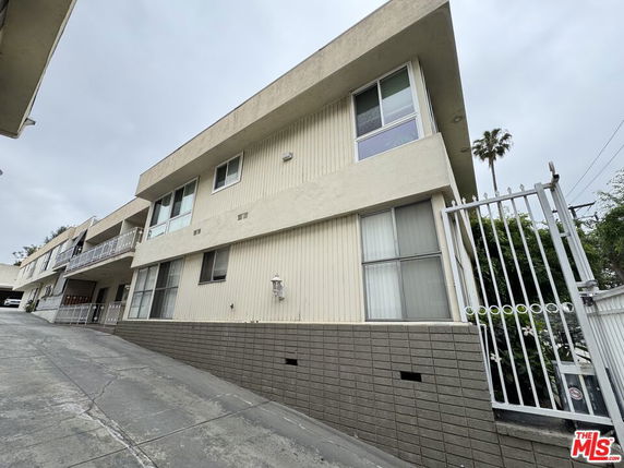 Front view of a multi-story building with gated entrance.
