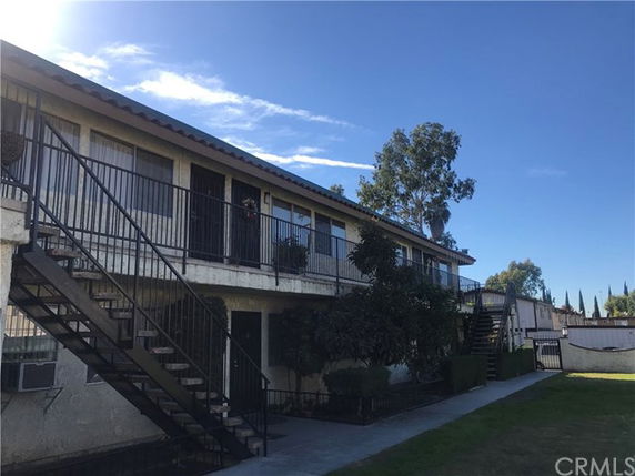 Front view of a two-story apartment building with external staircases.
