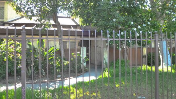 Front view of a house with a fence and a pathway leading to the entrance.